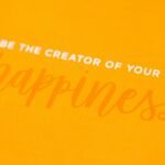 a yellow greeting card with the words be the creator of your own happiness