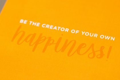 a yellow greeting card with the words be the creator of your own happiness